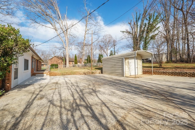 wooden deck featuring a carport and an outbuilding