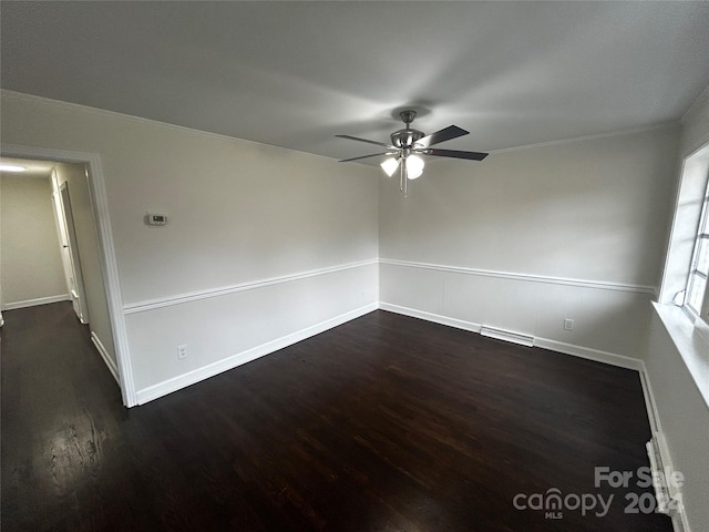 unfurnished room featuring ceiling fan, dark hardwood / wood-style flooring, and crown molding