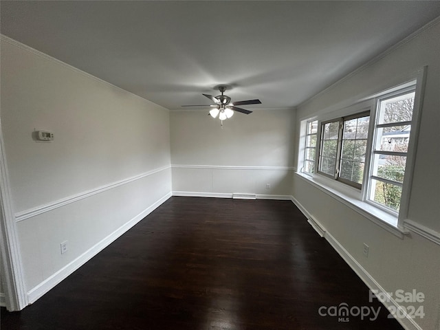 unfurnished room with ceiling fan, crown molding, and dark wood-type flooring