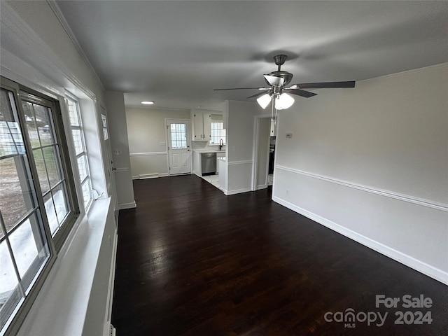 unfurnished living room with crown molding, sink, ceiling fan, and dark hardwood / wood-style floors