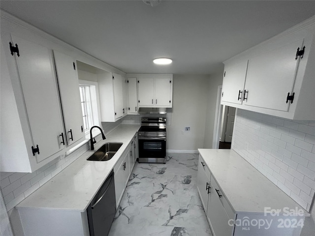 kitchen with decorative backsplash, white cabinetry, sink, and appliances with stainless steel finishes