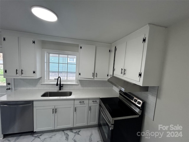 kitchen featuring decorative backsplash, white cabinetry, sink, and stainless steel appliances