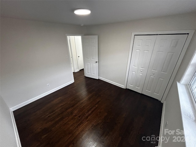 unfurnished bedroom featuring dark hardwood / wood-style flooring and a closet