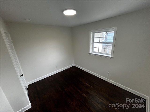 spare room with dark hardwood / wood-style floors