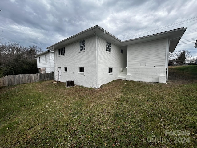 back of property featuring a yard and cooling unit