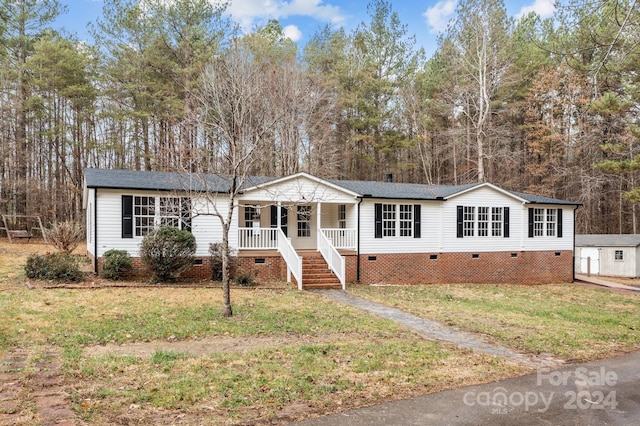 view of front of property featuring covered porch and a front lawn