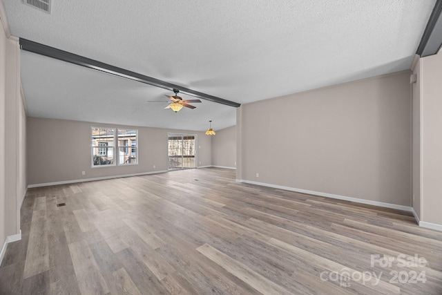 unfurnished living room featuring a textured ceiling, vaulted ceiling, light hardwood / wood-style flooring, and ceiling fan