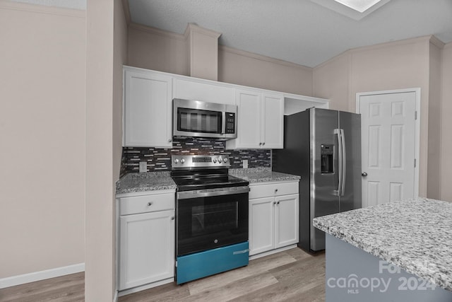 kitchen with decorative backsplash, white cabinetry, light wood-type flooring, and appliances with stainless steel finishes