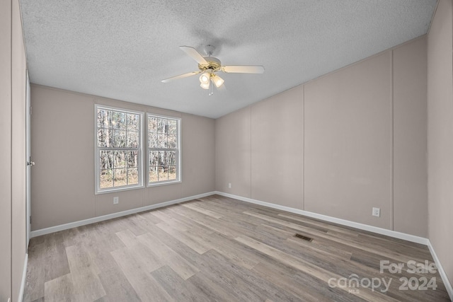 unfurnished room with ceiling fan, light hardwood / wood-style floors, and a textured ceiling