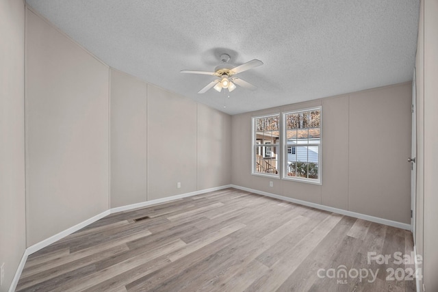 unfurnished room with ceiling fan, light hardwood / wood-style flooring, and a textured ceiling