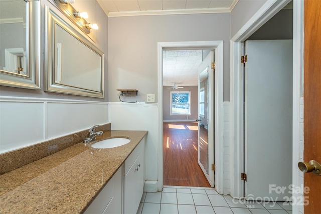 bathroom with crown molding, wainscoting, and tile patterned flooring