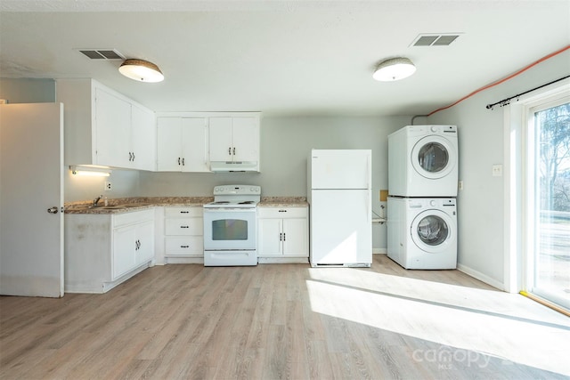 kitchen featuring white cabinetry, white appliances, under cabinet range hood, and stacked washer / drying machine