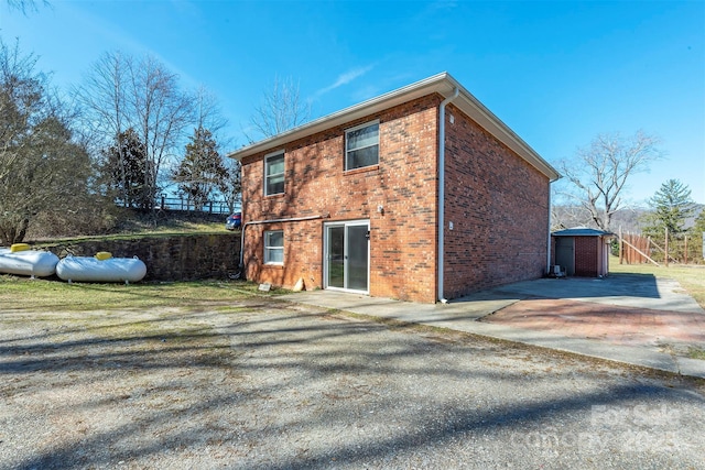 view of side of home with brick siding and fence