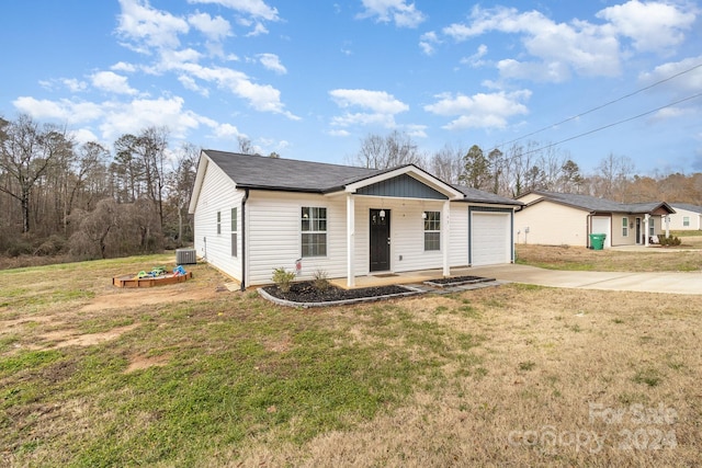 view of front of house featuring central AC unit, a porch, a garage, and a front yard