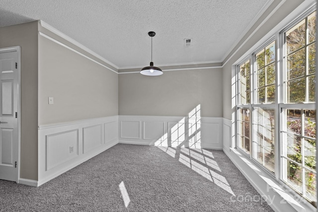 unfurnished dining area featuring crown molding, carpet, and a textured ceiling