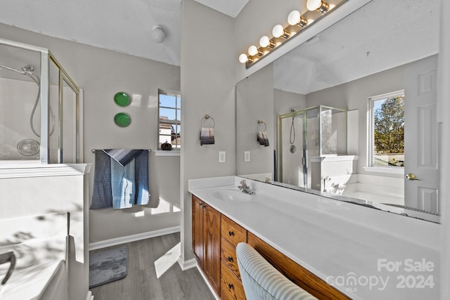 bathroom with hardwood / wood-style floors, vanity, an enclosed shower, and a textured ceiling