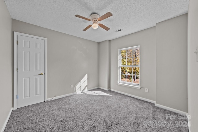 carpeted empty room featuring a textured ceiling and ceiling fan