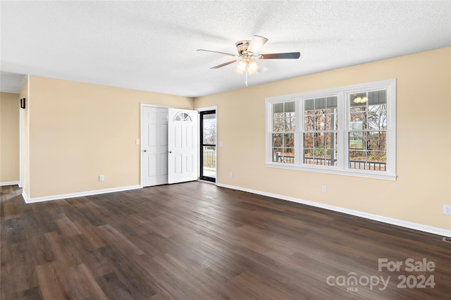 empty room featuring ceiling fan, dark hardwood / wood-style flooring, and a textured ceiling