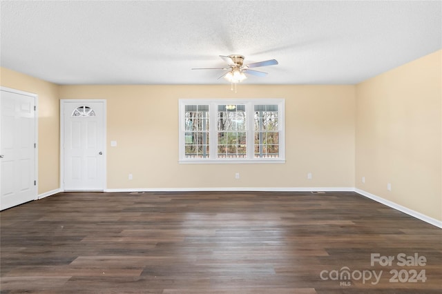 empty room with dark hardwood / wood-style floors, ceiling fan, and a textured ceiling