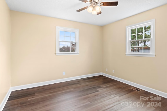 empty room with ceiling fan and dark wood-type flooring