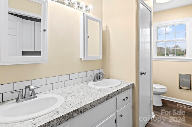 bathroom with hardwood / wood-style floors, vanity, and toilet