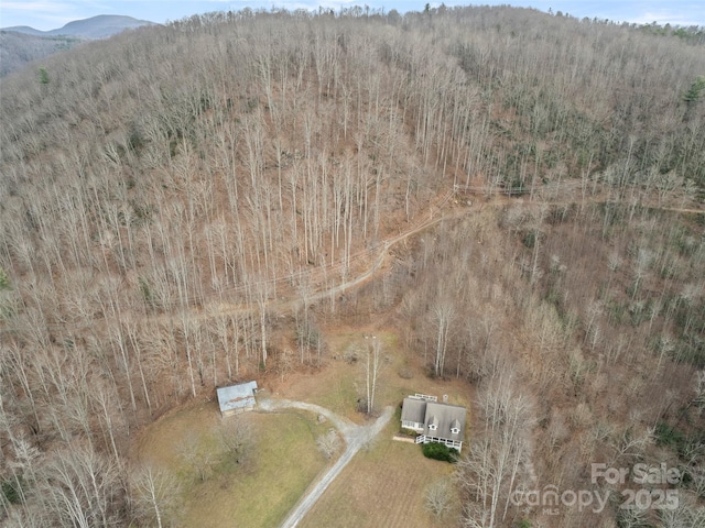 aerial view featuring a mountain view and a view of trees