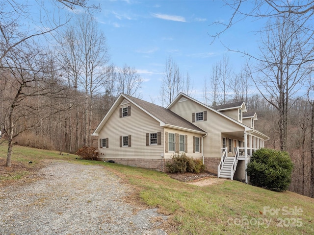 view of front of home with a porch, stairway, and a front lawn