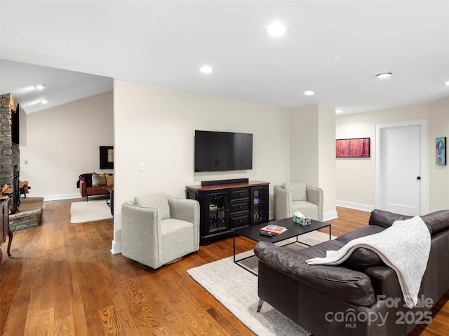 living area featuring baseboards, vaulted ceiling, wood finished floors, and recessed lighting