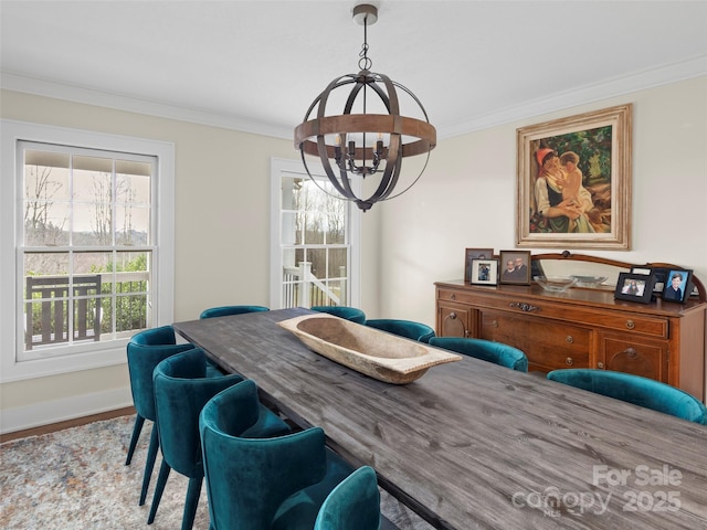 dining room with a chandelier, ornamental molding, and baseboards