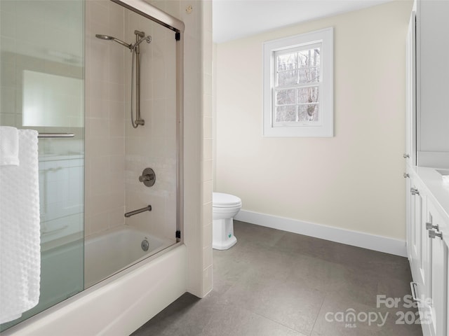 bathroom with toilet, baseboards, combined bath / shower with glass door, and vanity