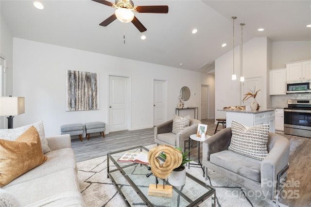 living room with high vaulted ceiling, light wood-type flooring, and ceiling fan