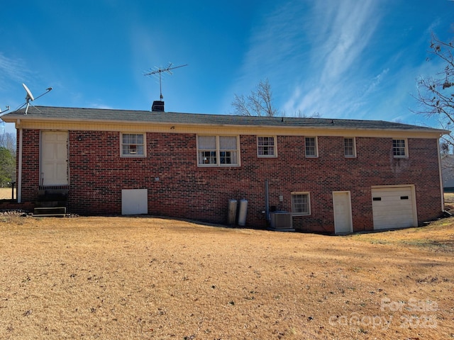 rear view of house featuring a garage and central air condition unit