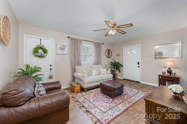 living room featuring ceiling fan, hardwood / wood-style floors, and a textured ceiling