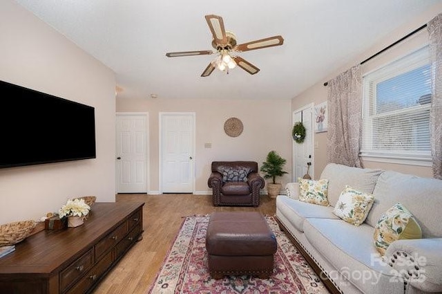 living room with light hardwood / wood-style flooring and ceiling fan