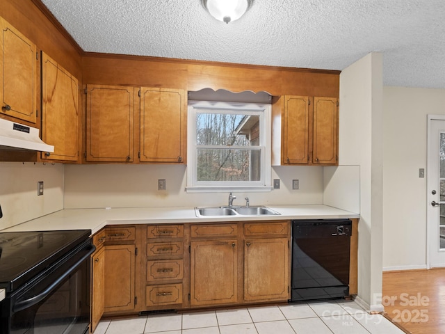 kitchen featuring light tile patterned floors, sink, a textured ceiling, and black appliances