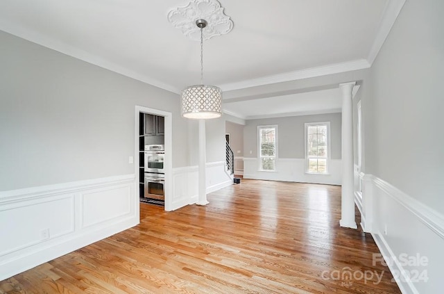 unfurnished dining area featuring crown molding and light hardwood / wood-style flooring