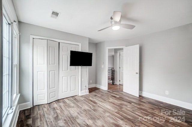 unfurnished bedroom featuring a closet, ceiling fan, and hardwood / wood-style flooring