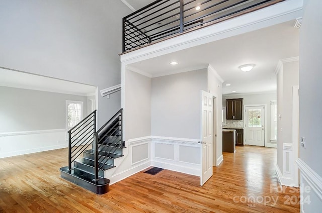 staircase featuring hardwood / wood-style flooring and crown molding