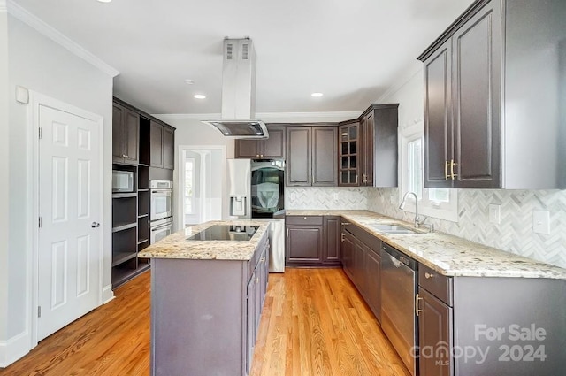 kitchen featuring sink, a center island, light hardwood / wood-style floors, island range hood, and appliances with stainless steel finishes