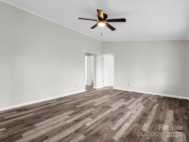 empty room with lofted ceiling, dark hardwood / wood-style floors, and ornamental molding