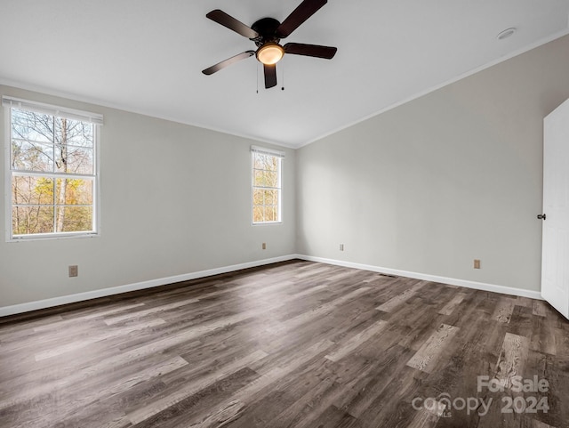 empty room with dark hardwood / wood-style floors, ceiling fan, and crown molding