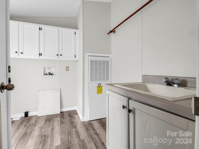 laundry room featuring washer hookup, cabinets, sink, and light hardwood / wood-style flooring