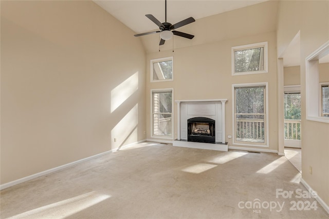 unfurnished living room featuring ceiling fan, light colored carpet, and high vaulted ceiling