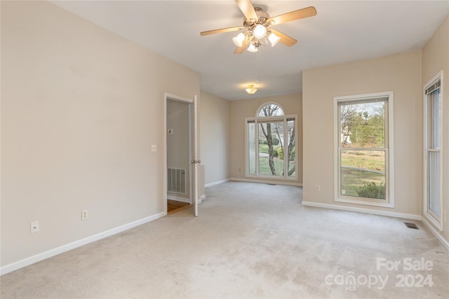 carpeted spare room with ceiling fan