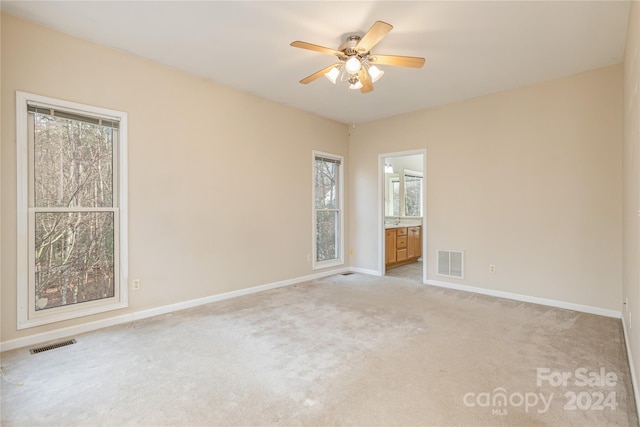 unfurnished room featuring light colored carpet and ceiling fan