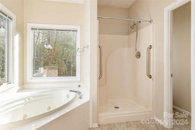 bathroom featuring separate shower and tub and a wealth of natural light