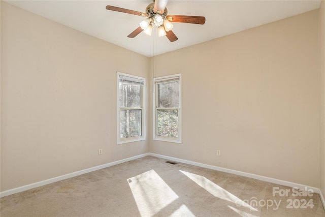 empty room featuring ceiling fan and light colored carpet