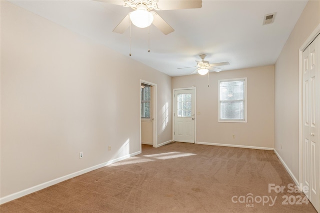 carpeted spare room with ceiling fan