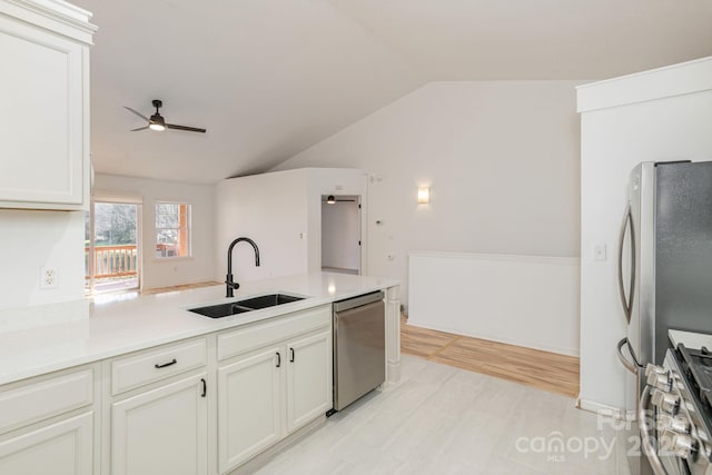 kitchen with white cabinets, sink, vaulted ceiling, ceiling fan, and stainless steel appliances