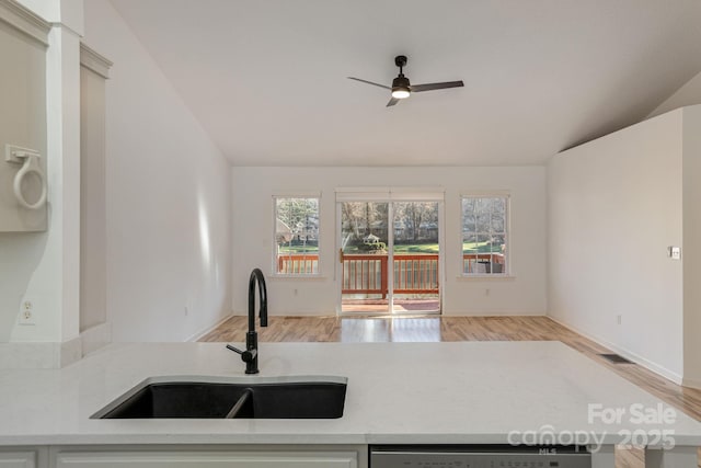 kitchen with lofted ceiling, sink, ceiling fan, light wood-type flooring, and dishwashing machine